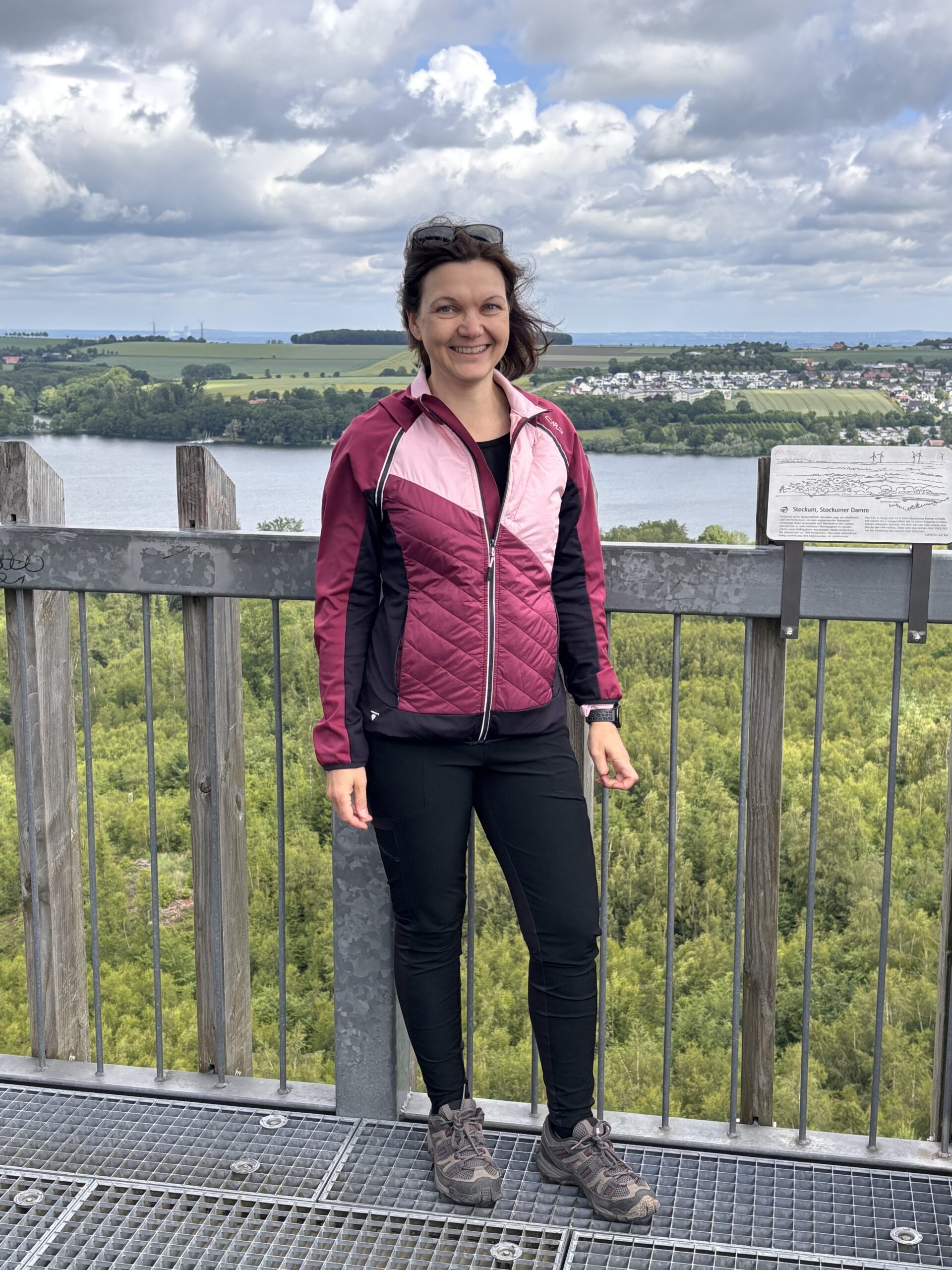 Britta Reinecke beim Wandern auf einem Aussichtsturm über dem See